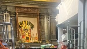 Interior view of Sri Raghavendra Swamy Mutt in Bhuvanagiri, showing the idol of Guru Raghavendra and the Mrittika Vrindavana adorned with flower garlands.