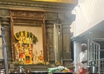 Interior view of Sri Raghavendra Swamy Mutt in Bhuvanagiri, showing the idol of Guru Raghavendra and the Mrittika Vrindavana adorned with flower garlands.