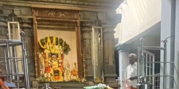 Interior view of Sri Raghavendra Swamy Mutt in Bhuvanagiri, showing the idol of Guru Raghavendra and the Mrittika Vrindavana adorned with flower garlands.