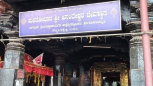 Entrance of the Mahatobhara Shri Anantheshwara Temple in Udupi, featuring a blue signboard in Kannada mentioning it as the place of Shri Madhvacharya's disappearance.