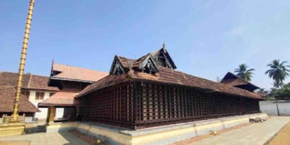 Traditional Kerala style architecture of Thiruvaruppu Sri Krishna Temple in Kottayam with a golden sanctum and tiled roof under a clear blue sky
