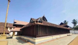 Traditional Kerala style architecture of Thiruvaruppu Sri Krishna Temple in Kottayam with a golden sanctum and tiled roof under a clear blue sky