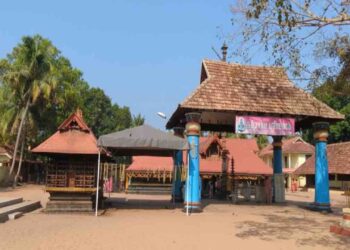 Entrance and courtyard view of the ancient Thiruvizha Mahadeva Temple in Alappuzha, Kerala, featuring traditional Kerala style architecture with tiled roofs and blue pillars.