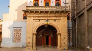 Intricate stone entrance arch of the historical Toravi Lakshmi Narasimha Temple in Vijayapura, Karnataka, with ancient inscriptions in Kannada and detailed carvings under a clear sky.