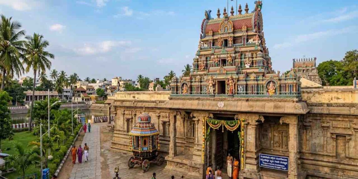 A detailed wide shot of the Satyandheshwara Swamy Ganapati Temple near Kumbakonam, Thanjavur, showing its colourful Dravidiyan gopuram and granite walls in daylight.
