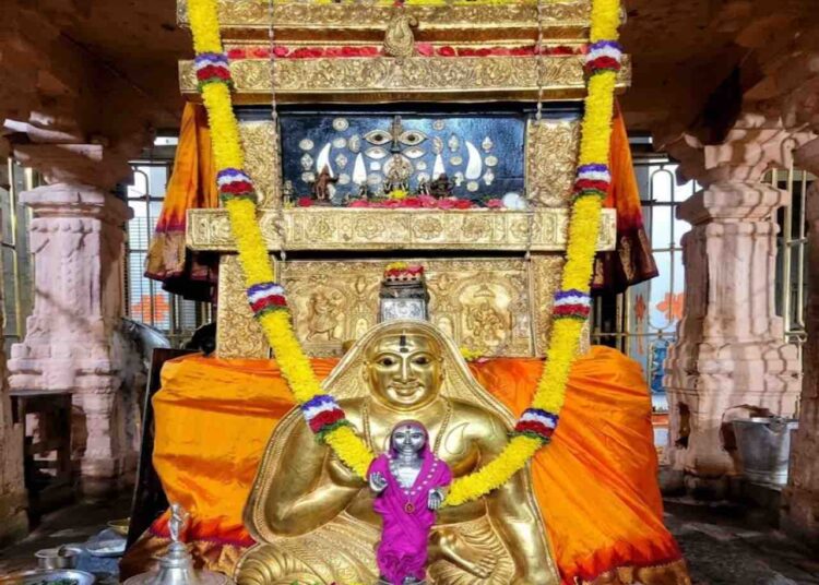 The sacred Moola Vrundavana of Sri Raghavendra Swamy in Mantralaya, adorned with a golden kavacha, flower garlands, and traditional offerings.