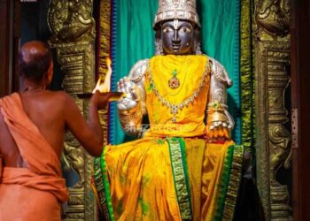 Idol of Lord Rogamochana Dhanvanthri at Uttaradi Math Mysore with a priest performing Aarti.