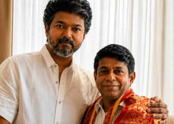 Actor Vijay posing with astrologer Radhan Pandit during an indoor meeting