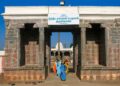 Main entrance gateway of the historic Nithya Kalyana Perumal Temple in Thiruvedanthai, Tamil Nadu, with devotees entering and a clear blue sky.