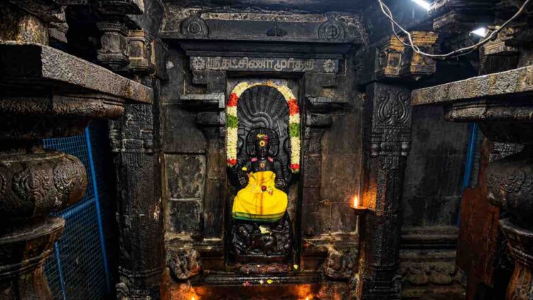Sanctum of Sri Suddha Ratneswarar Temple at Oottathur, Tamil Nadu, featuring the sacred deity amidst ancient stone architecture and oil lamps.