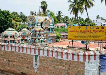 A detailed wide-angle photograph of the historic Uthamar Kovil temple complex near Tiruchirappalli, Tamil Nadu, showcasing several intricately decorated gopurams (temple towers) and mandapams.